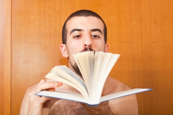 Człowiek czytając książkę na łóżku — Zdjęcie stockowe