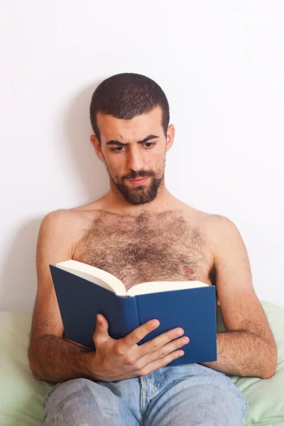 Homem lendo um livro na cama — Fotografia de Stock