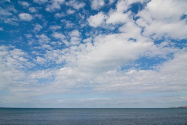 Vue grand angle de la mer avec un ciel nuageux au-dessus — Photo