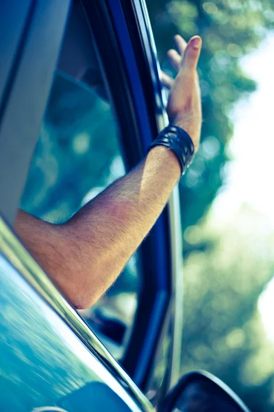 Brazo del hombre fuera de la ventana del coche — Foto de Stock
