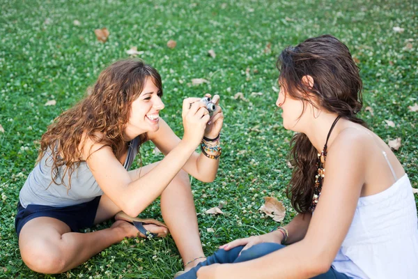 Menina no parque levando fotos para seu amigo fêmea — Fotografia de Stock