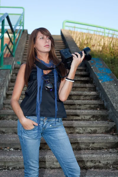 Chica joven agradable con una cámara profesional — Foto de Stock