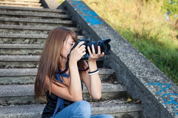 Menina nova agradável com uma câmera profissional — Fotografia de Stock