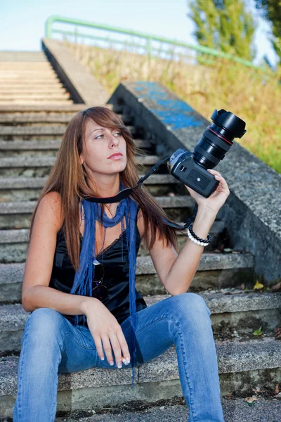 Chica joven agradable con una cámara profesional — Foto de Stock