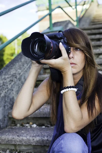Nettes junges Mädchen mit einer professionellen Kamera Stockbild