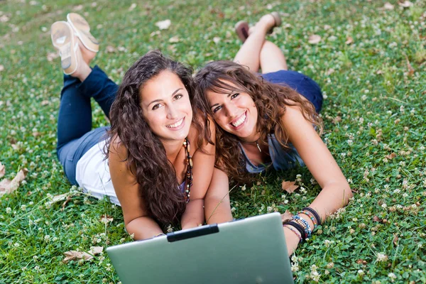 Twee jonge vrouw met laptop pc op park — Stockfoto