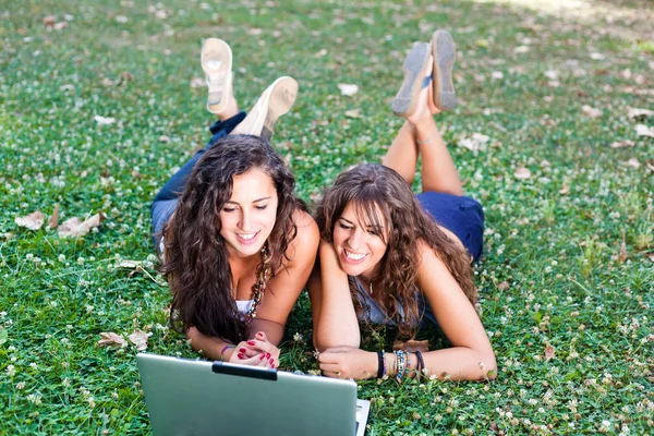Dos mujer joven con PC portátil en Park —  Fotos de Stock