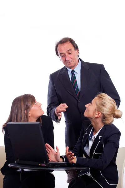 Chefe com raiva de duas empresárias conversando em vez de trabalhar — Fotografia de Stock