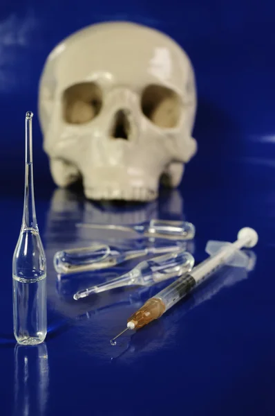 Ležela injekční stříkačka, ampule a lebka — Stock fotografie