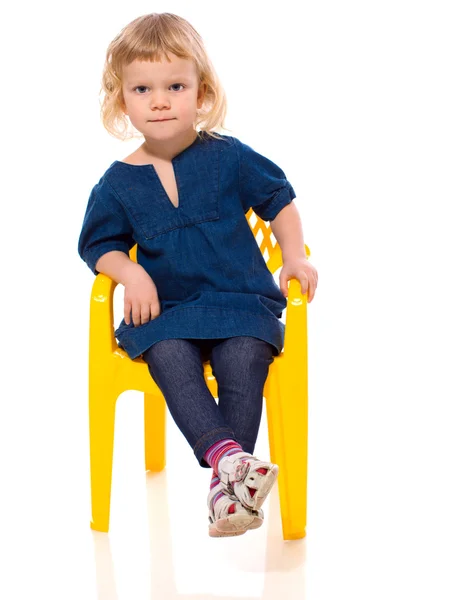 Pieni tyttö istuu — kuvapankkivalokuva