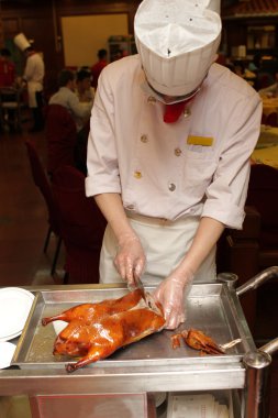 Chinese cook prepares Peking Duck clipart