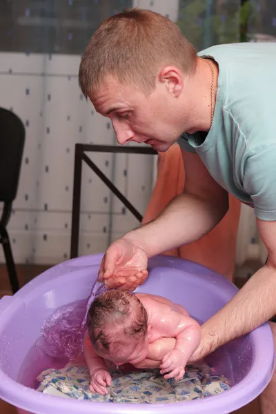 Pai lava seu bebê — Fotografia de Stock