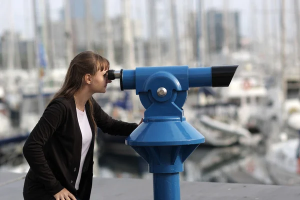 Jeune femme regarde à travers le télescope — Photo