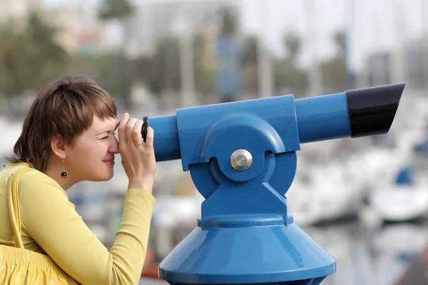 Mulher olha através do telescópio — Fotografia de Stock