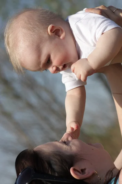 Mãe joga para cima seu bebê — Fotografia de Stock