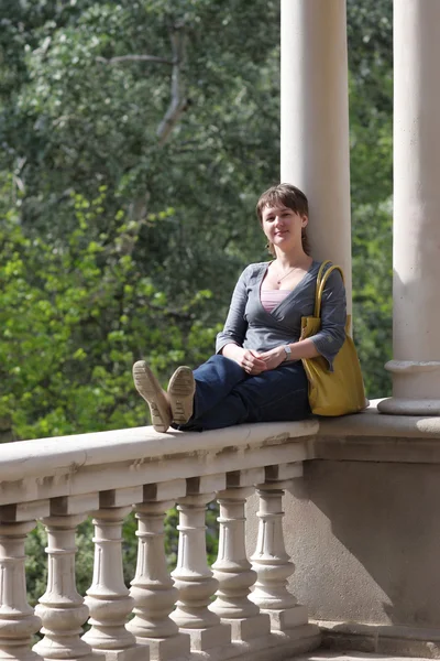 Kvinna sitter på balkongräcket — Stockfoto