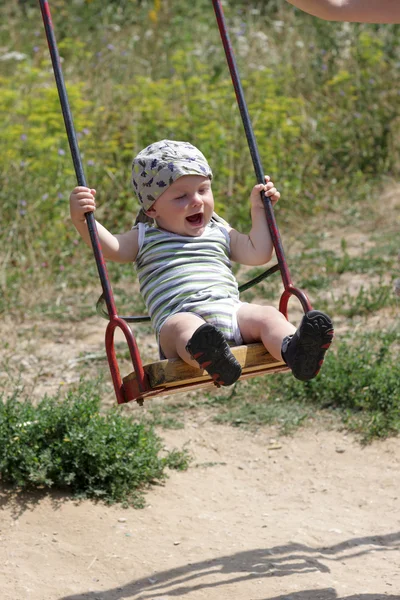 Happy baby is swinging — Stock Photo, Image