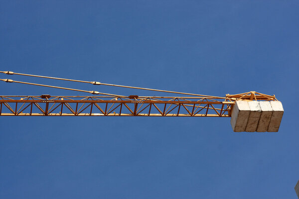 The crane holds a load on a sky background