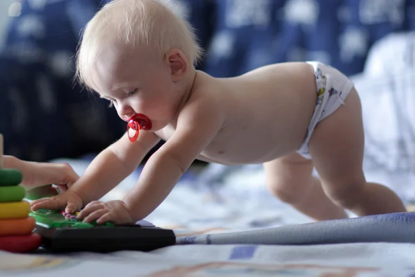 Säugling spielt auf Spielzeugklavier — Stockfoto