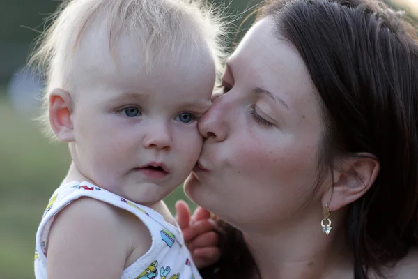 Мама целует своего малыша — стоковое фото