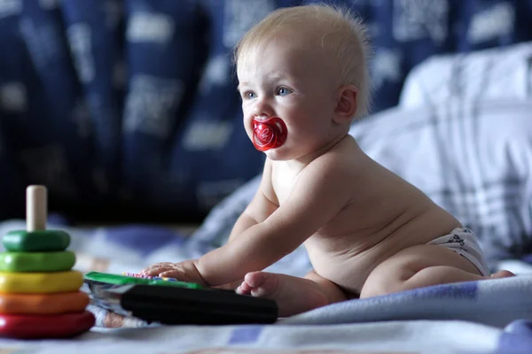 Baby plays on bed — Stock Photo, Image