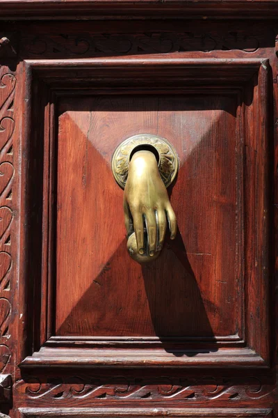 Бронзовая рука на двери — стоковое фото