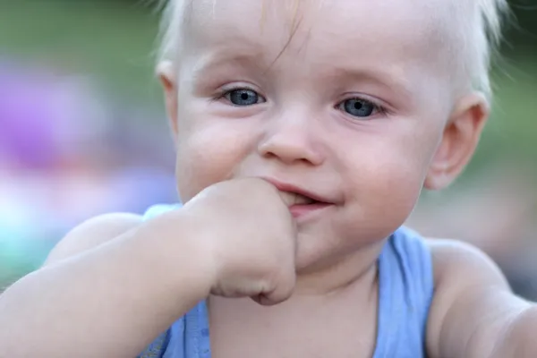Забавна дитина смокче його палець — стокове фото