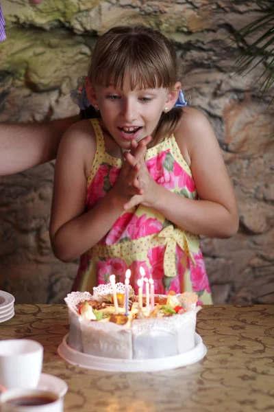 Glada tjejen ser på tårta — Stockfoto