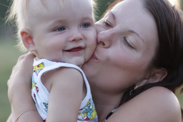 Matka całuje szczęśliwe dziecko — Zdjęcie stockowe