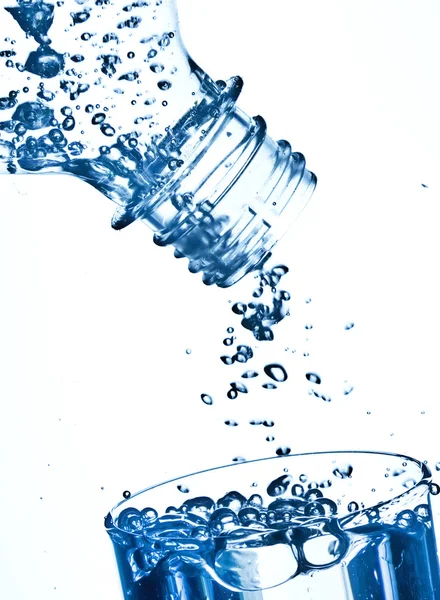 Бутылка в чистой воде с волнами и пузырьками — стоковое фото