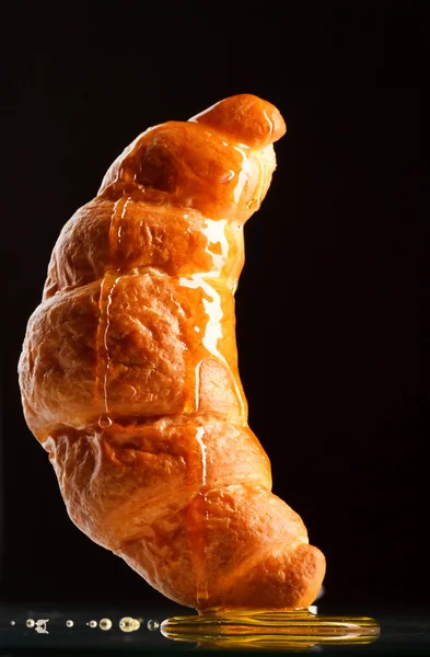 Fresh croissant with honey — Stock Photo, Image