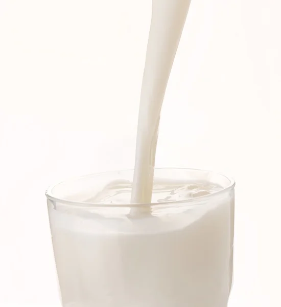 Milk pouring in glass — Stock Photo, Image