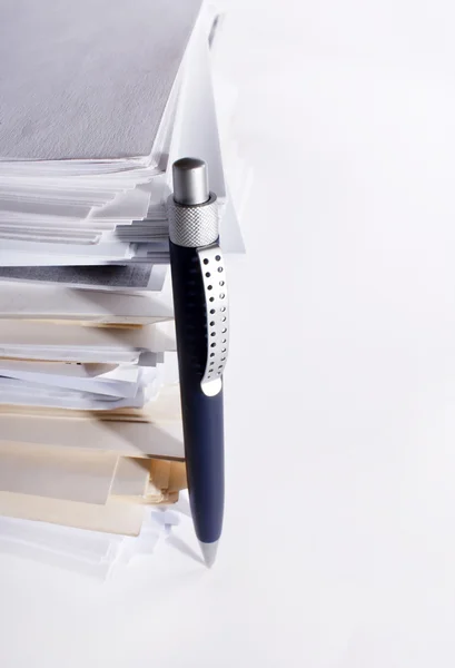 Een pen in de buurt van stapel papier — Stockfoto