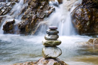 Pebble stones over waterfall clipart