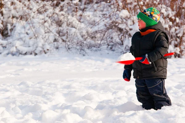Kleiner Junge spielt mit Schnee — Stockfoto