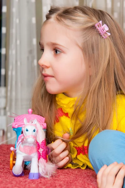 stock image Little girl with a toy horse