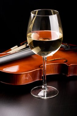 Violin and a glass of wine on the table clipart