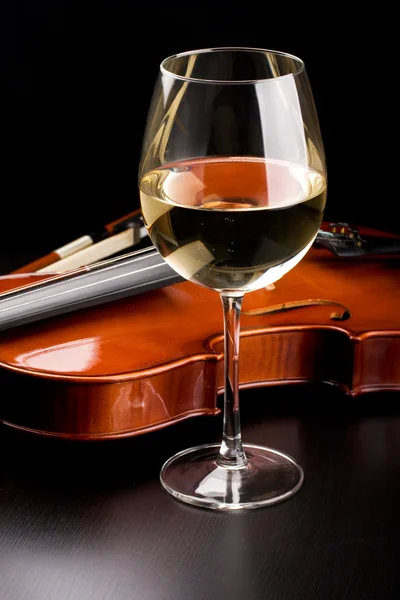 Скрипка и бокал вина на столе — стоковое фото