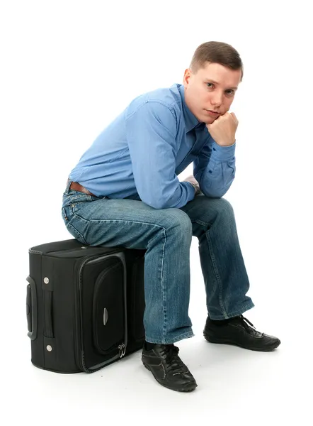 Zamyšlený mladý muž sedí na ruce pytel — Stock fotografie