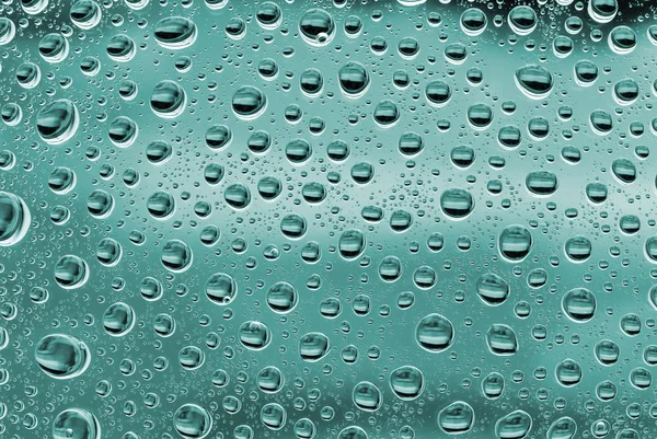 Пузырьки воды на зеленом стекле — стоковое фото