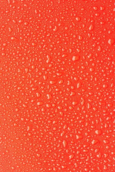 Regentropfen auf rotem Kunststoff — Stockfoto