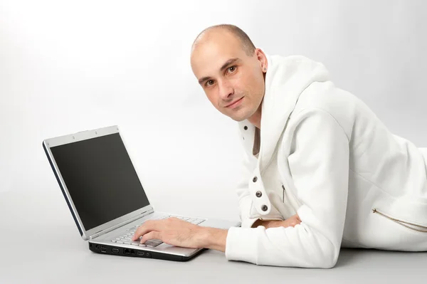 Portret van een jonge man met behulp van een laptop — Stockfoto