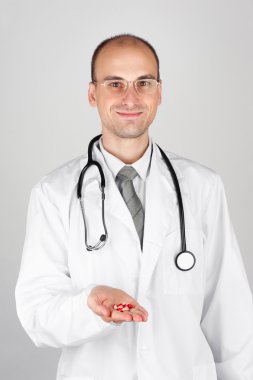 Young doctor offering pill clipart