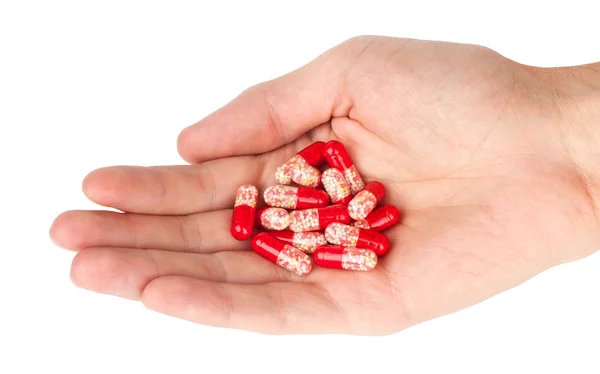 Mão humana segurando pílulas vermelhas — Fotografia de Stock