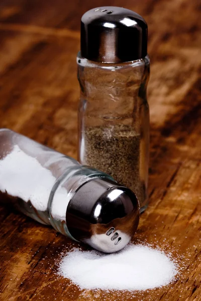 Salt and black pepper in shakers — Stock Photo, Image