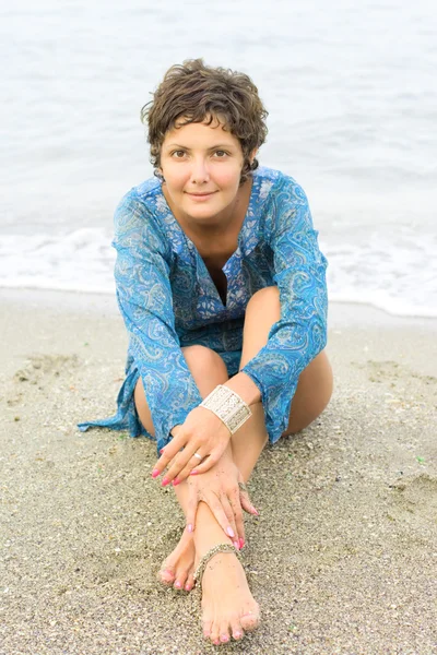Kobieta w niebieskiej sukience na plaży — Zdjęcie stockowe