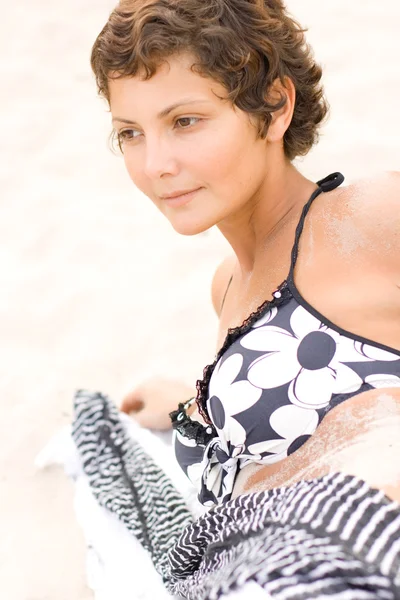 Bruna donna sdraiata su una sabbia — Foto Stock