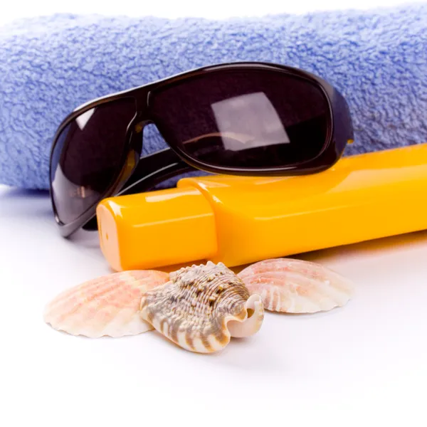 Asciugamano, conchiglie, occhiali da sole e lozione — Foto Stock