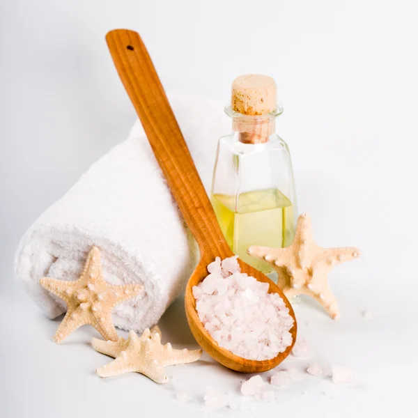 Sea salt on wooden spoon, towel, oil and stars — Stock Photo, Image