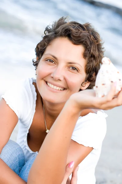 Woman on seacoast with a cockleshell — Stock Photo, Image